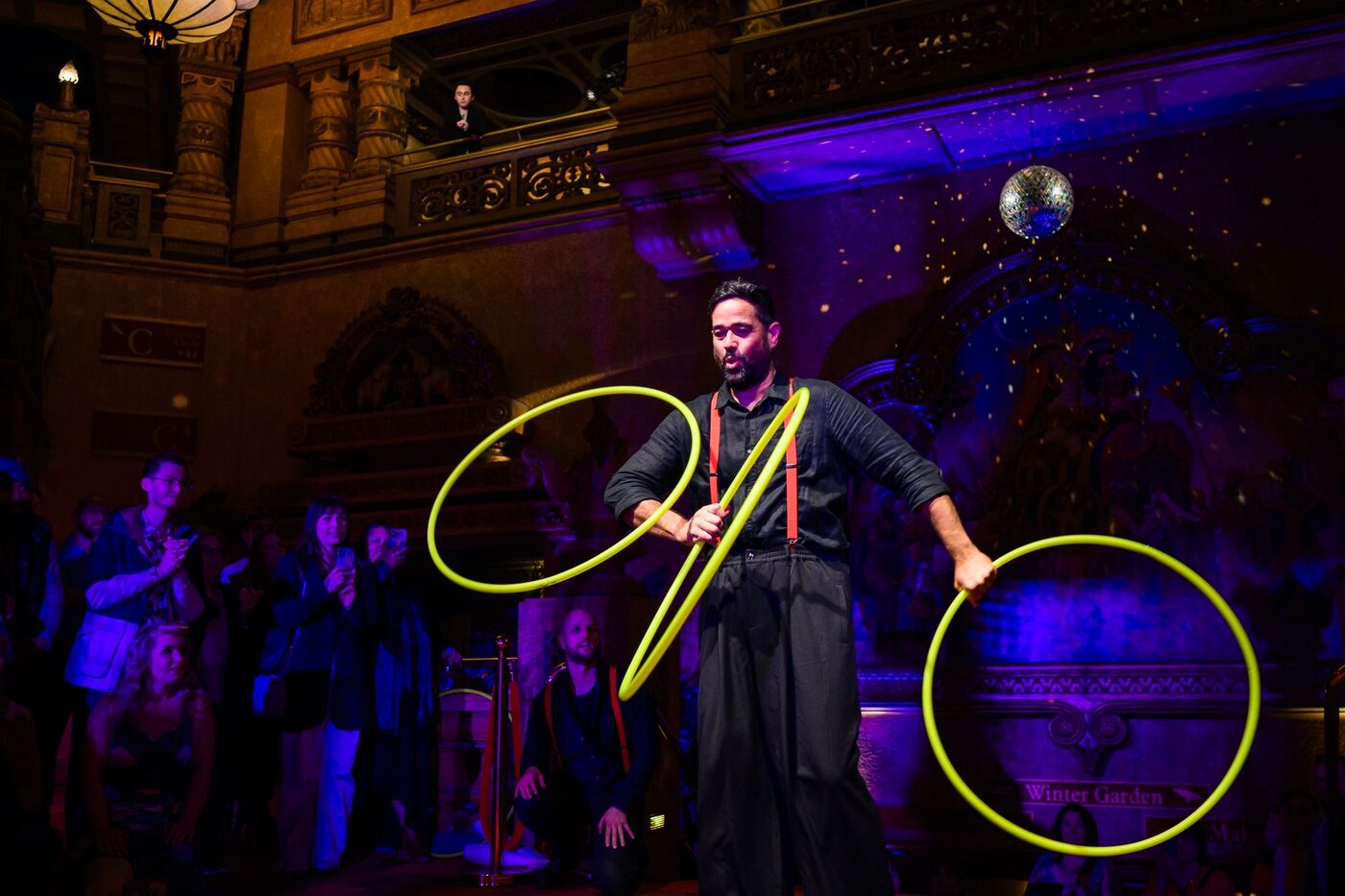 The Catching Machine performing hoop juggling on a theatre stage